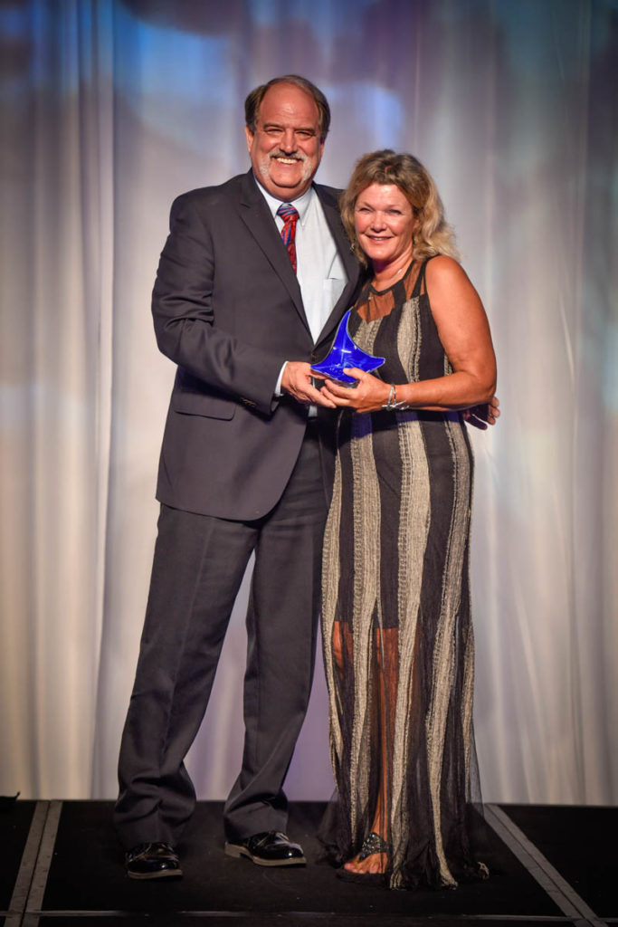 Lois Hatcher receives her Stingray Award for Watersports Employee of the Year from co-coordinator of the Magic Reef Restoration Project Keith Sahm, Operations Manager at Sunset House. Photo courtesy Cayman Islands Tourism Association.