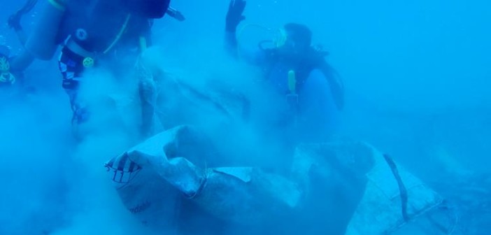 Underwater "high 5" between two volunteers who believe in the cause. Photo courtesy Cayman Magic Reef Restoration Project.