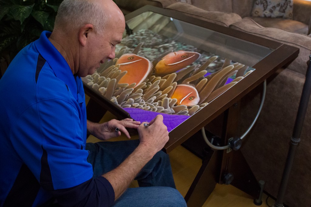 Marty Snyderman signing one of his prints. Several will be awarded in a drawing to raise money for the Magic Reef Restoration Project. Photo courtesy Marty Snyderman